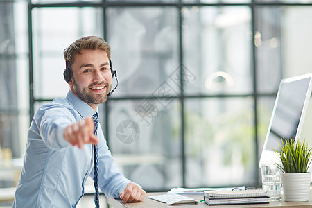 手持耳机和膝上型计算机的人在办公室工作监视男性职业代理人操作员职场客户服务呼叫电脑图片