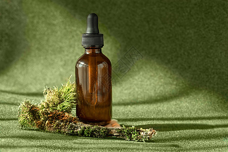 含血清的安珀玻璃瓶 必需的油 抗老古代科林美容品 在绿苔色背景中图片