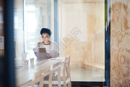 在会议前整理一下 一名女商务人士在办公室里用数码平板电脑工作图片
