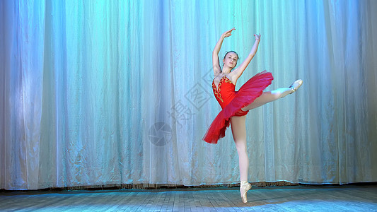 年轻芭蕾舞者穿红色芭蕾舞裙和指尖鞋 跳优雅的芭蕾运动 巡回童话表演及节奏短剧图片