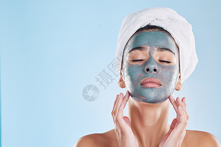 在蓝色背景的工作室里 面部 护肤品和带面膜霜的女性 用于美容 健康和保健 化妆品 产品和年轻女孩在豪华水疗中心接受模型肖像中的痤图片
