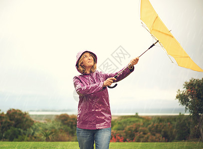 只要一点晴朗的天空就会有所帮助 一个女人站在雨中 撑着雨伞抬头仰望天空图片