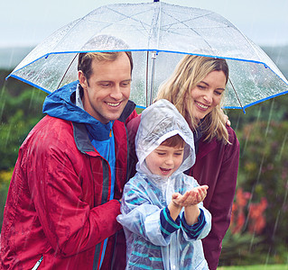 他对雨水着迷 一个三口子的家庭 站在外面的雨中图片