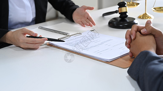 律师照片素材律师在合同文件上显示签名位置并向其客户提供法律咨询和法律建议的裁剪照片背景