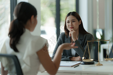 女商务人士和律师在办公室的木桌上讨论带有黄铜秤的合同文件 法律 法律服务 咨询 正义概念电脑立法判决书成人协议金融投资桌子平衡起图片