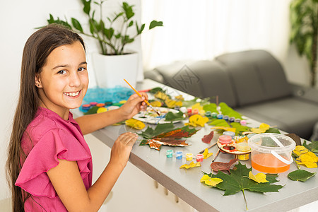 小女孩在家中涂上刷子和秋天艺术的颜料女孩水彩幼儿园婴儿落叶绘画学校童年儿童木头图片