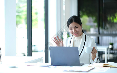 视频演示会议年轻的亚洲女商务人士在办公室使用视频通话进行演示屏幕呼唤营销笔记本商务统计生长网站成功投资图片