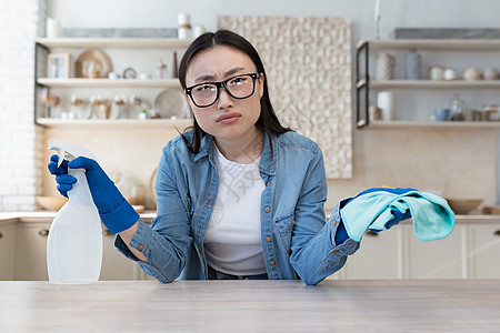 望着摄影机的女主妇戴眼镜看相片 对不满意的亚洲年轻妇女的肖像一目了然图片