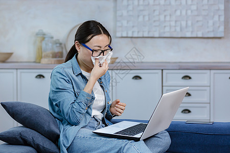 与心理学家进行在线视频咨询 一名戴眼镜的亚洲女性独自在家图片