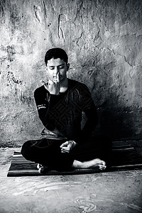 身穿黑衣服的青春男子在彩色垫子上做Pranayama或pranayam或呼吸控制瑜伽图片