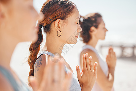 女性朋友在海滩上训练瑜伽练习时冥想 一群禅宗女运动员在户外锻炼 内心平静 平衡 在健身生活方式中获得健康或健康图片