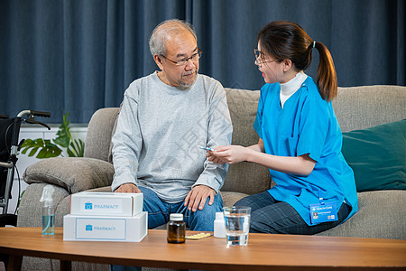 在养老院向老年男子出示处方药的女护士护理员保险处方咨询瓶子保健护理卫生医院讨论药品图片