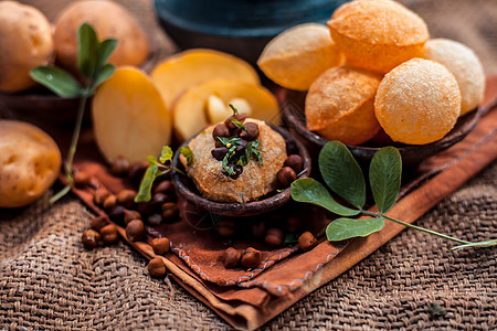 著名的印度和亚洲街头美食 即盛在粘土碗中的 Golgappa 小吃 以及盛在另一个粘土容器中的调味辛辣水 小吃及其配料的水平拍摄图片