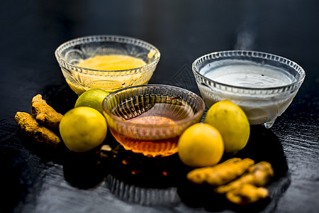柠檬汁 蜂蜜和凝乳的面膜 以及一些生姜黄在玻璃碗中与木质表面上的所有原料充分混合 用于易长粉刺的皮肤和瑕疵黑头毛孔蔬菜牛奶治愈公图片