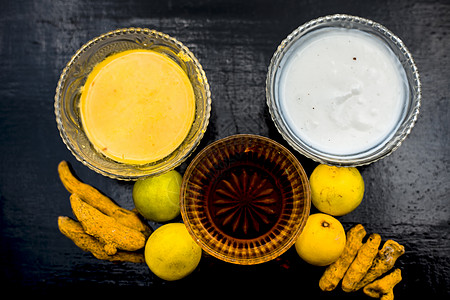 柠檬汁 蜂蜜和凝乳的面膜 以及一些生姜黄在玻璃碗中与木质表面上的所有原料充分混合 用于易长粉刺的皮肤和瑕疵擦洗美容仪式毛孔化妆品图片