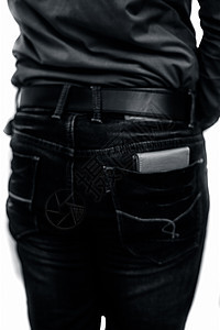 一名商务人士身穿蓝色衬衫和蓝色牛仔裤 系着黑色腰带 背面口袋里放着皮革钱包的背面照片 与白色隔离图片