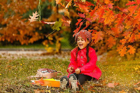 一个可爱小女孩的肖像 假扮秋天公园女学生学生幸福孩子闲暇童年乐趣晴天教育公园图片