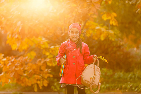 小学学生手头拿着书 在户外建筑附近有背包的女孩 开始上课 第一天秋天 笑声时间童年时尚书包孩子小学生女学生学校女性街道图片