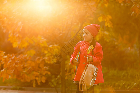小学学生手头拿着书 在户外建筑附近有背包的女孩 开始上课 第一天秋天 笑声学校孩子童年女学生女性时间小学生街道时尚书包图片