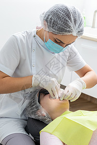 在牙科办公室安装一名病人脸颊切除器的牙医牙齿橡皮专家药品假牙程序检查口腔科工具诊所图片