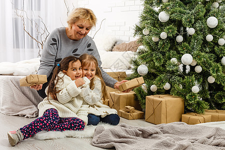 圣诞快乐 节日快乐 外婆和孩子们 早上的Xmas 亲爱的肖像家庭房间女士乐趣女孩祖母季节女儿妈妈时间房子图片