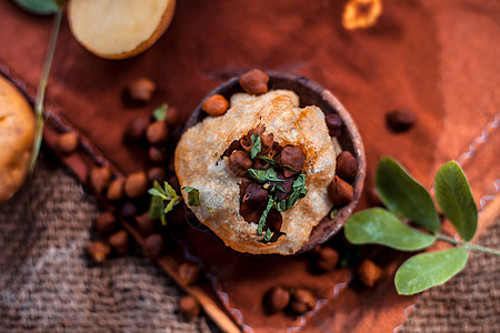 著名的印度和亚洲街头美食 即装在粘土碗中的 Panipuri 小吃 以及装在另一个粘土容器中的调味辛辣水 整个由原料组成的表面存图片