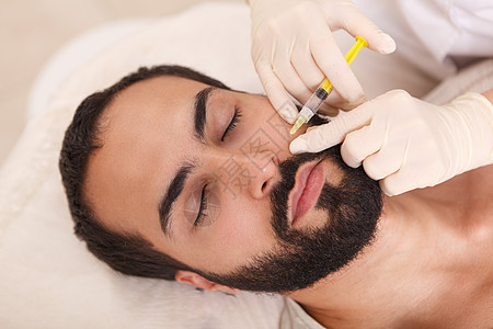 男性客户在美容诊所注射填充剂治疗美容师注射器男人胶原填料外科药品女性手术图片