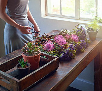 将自然带入室内 一个漂亮的花卉花束正在木制柜台顶上完成图片