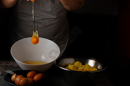 女人穿着白色围裙 在碗里吃鸡蛋台面手指食物厨房女性家庭土豆营养主妇美食图片