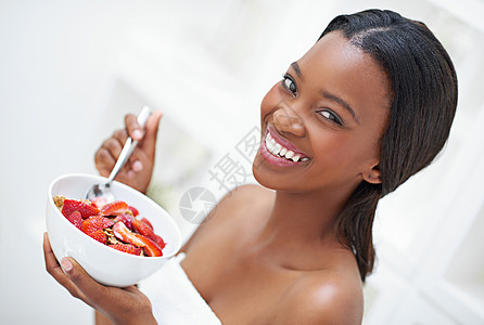我早上开始吃草莓了 一位美丽的年轻女人 吃着一碗草莓的美食图片