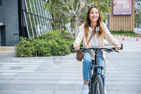 快乐的亚洲美丽的年轻女性 在建筑城市附近的露天街上骑自行车旅行帽子街道齿轮公园运输女孩自由运动女士图片