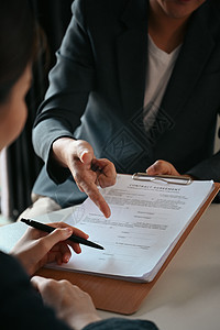 与木制桌上熟练律师签署协议的商业女商务人士的裁剪片段图片
