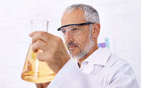 对结果着迷 一位成熟的男性科学家检查他的化学实验的结果图片