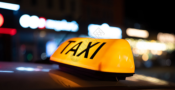 街上的计程车牌灯出租车城市驾驶夜生活车辆反射商业运输汽车黄色图片