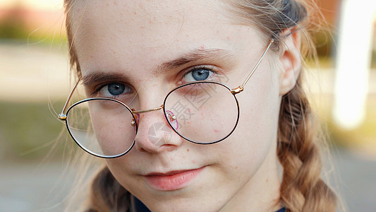一个戴眼镜的十几岁女孩 脸贴近了情感微笑女性头发教育女士女学生乐趣喜悦学校图片