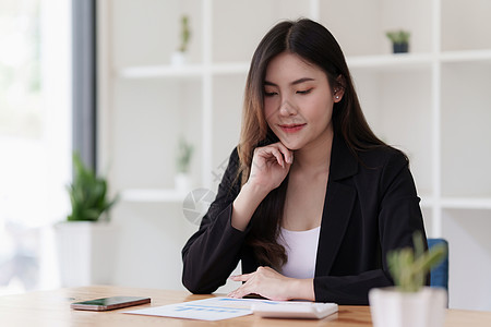 亚洲女商务人士与业务团队通过手机通话分析技术价格图表和指标 帐户或存钱或保险概念计算兴趣支付预算订金笔记本基金成功会计电脑图片