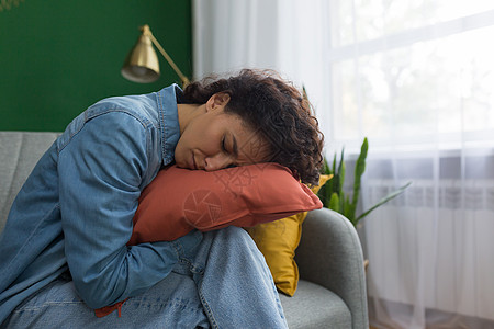 在家睡在沙发上抱枕的美女 西班牙裔女人睡累了图片