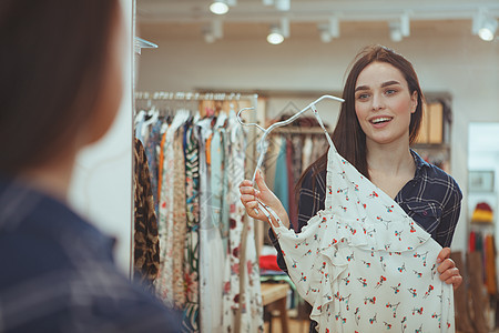 在服装店买衣服的迷人年轻女子裙子店铺折扣客户零售镜子设计师闲暇狂欢顾客图片