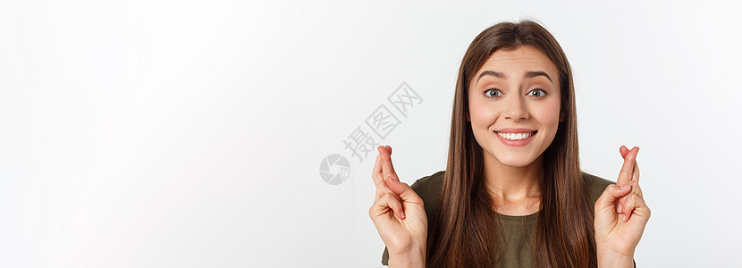 特写肖像希望美丽的女人交叉她的手指 睁开眼睛 希望 问最好孤立在灰色的墙壁背景上工作室快乐成人白色学生女士运气女孩幸福头发图片