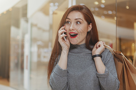 美丽的女人在商场享受购物狂欢细胞互联网销售购物袋中心价格购物中心顾客购物者零售图片