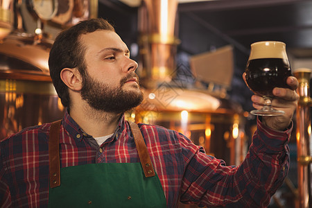 在他的手工艺啤酒制造厂工作的男人酿酒业企业家贮存工艺酒精围裙技术员木工人质量食谱饮料图片