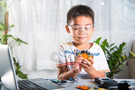 幼小孩子尝试组装 制造车轮和汽车玩具学生电脑技术蒸汽编码项目创新作坊机器人俱乐部图片