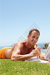 在泳池边阅读一本好书放松身心 一个微笑的男人在池畔放松图片
