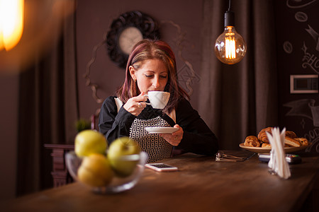 成功的成年女商务人士在酒吧柜台喝咖啡时 享受着她的一杯咖啡服装通讯餐厅电话夜店消息现实活动手机酒杯图片