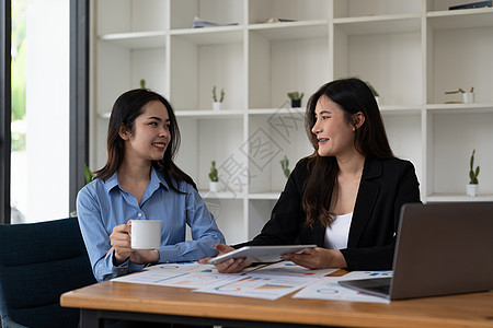 两位亚洲商业女工在办公室时笑着微笑和充满自信地一起工作 并当面微笑;以及图片