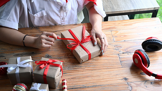 被割伤的年轻女子 在木制桌上打开圣诞礼物盒图片