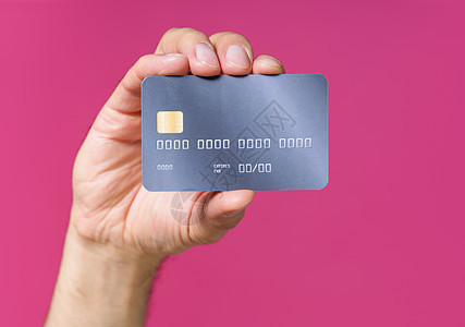 最佳报价 深灰色的尖锐借记 人手信用卡与粉红色背景隔绝 金融 银行概念 没有可见的脸部图片
