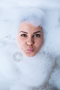 一个女孩在浴缸里的特写肖像和她脸上的白色泡沫 不同的情绪 鬼脸 女人的微笑浴室护理成人女士乐趣治疗肥皂卫生身体女孩图片