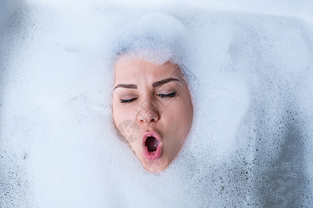 一个女孩在浴缸里的特写肖像和她脸上的白色泡沫 不同的情绪 鬼脸 女人的微笑女孩皮肤浴室治疗成人淋浴温泉洗澡身体肥皂图片