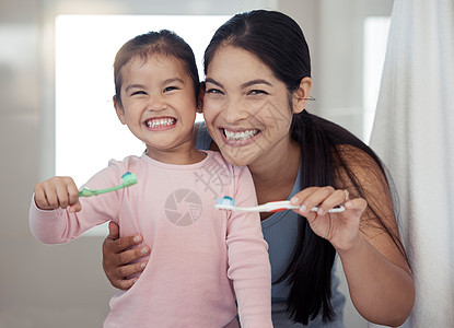 妈妈和孩子刷牙的肖像 牙齿健康和在家里的浴室清洁 快乐的母亲和女孩学习口腔保健 健康和清新口气 以获得牙刷 牙膏和微笑图片